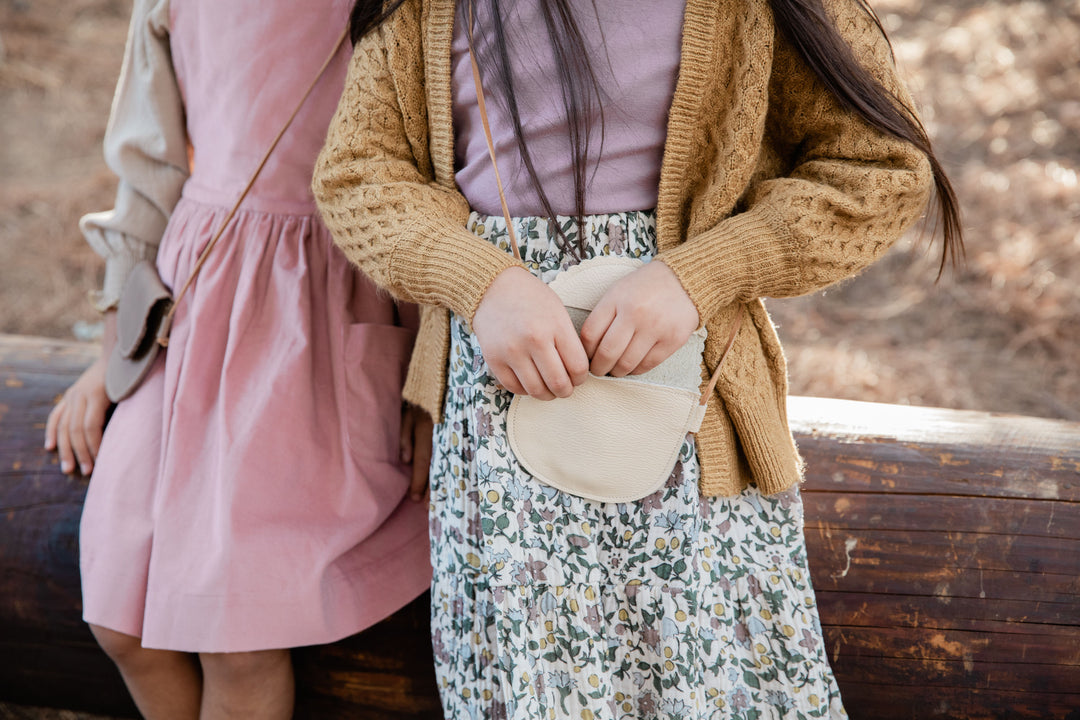 girl holding crossbody cream leather purse