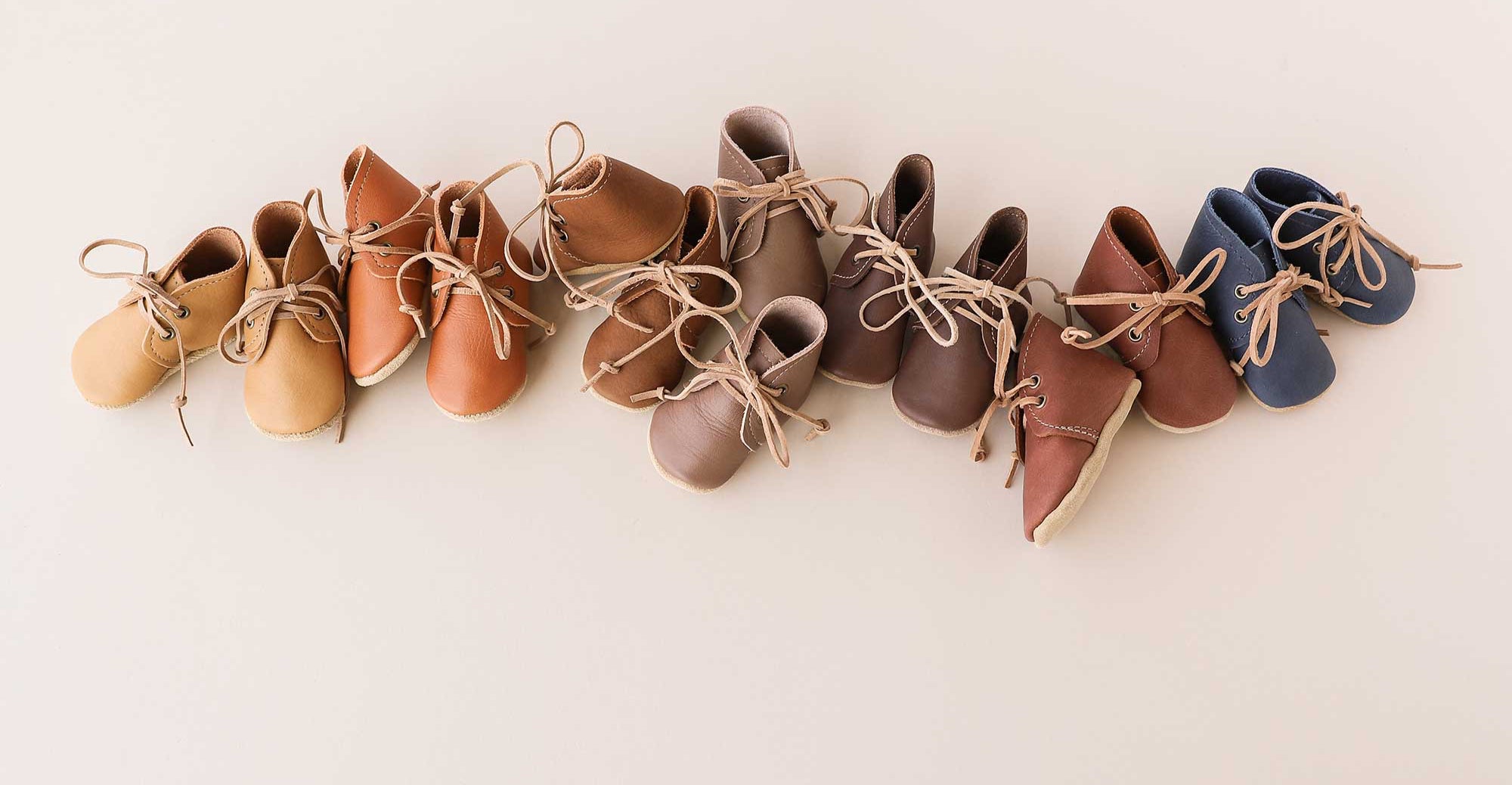 Row of baby shoes in various colors on a light background