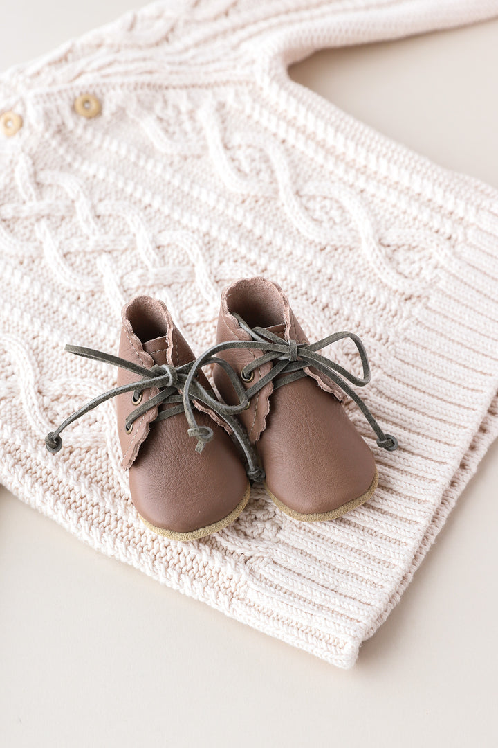 pair of taupe clay leather boots with hunter green laces