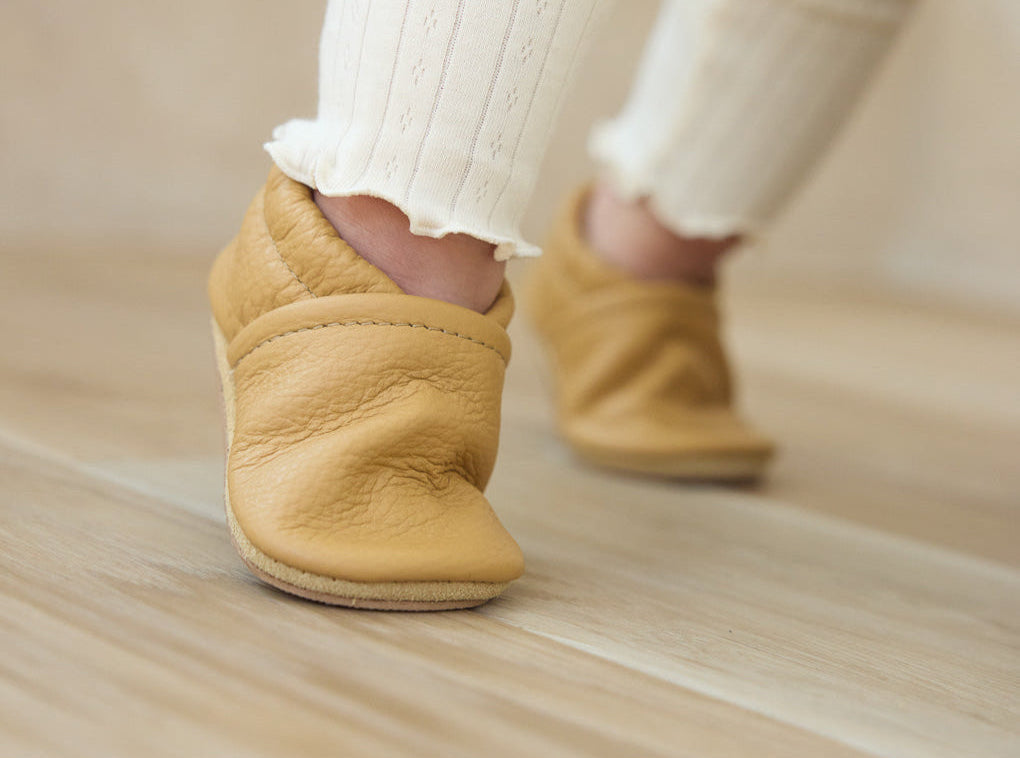 light brown shoes on standing toddler feet