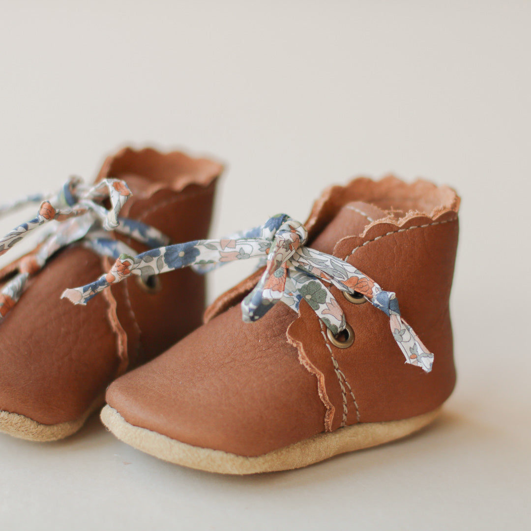 medium brown leather baby girl boots with scalloped edge. Soft soles. Product image. Floral laces.  Edit alt text