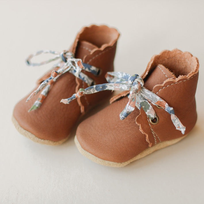 medium brown leather baby girl boots with scalloped edge. Soft soles. Product image. Floral laces.