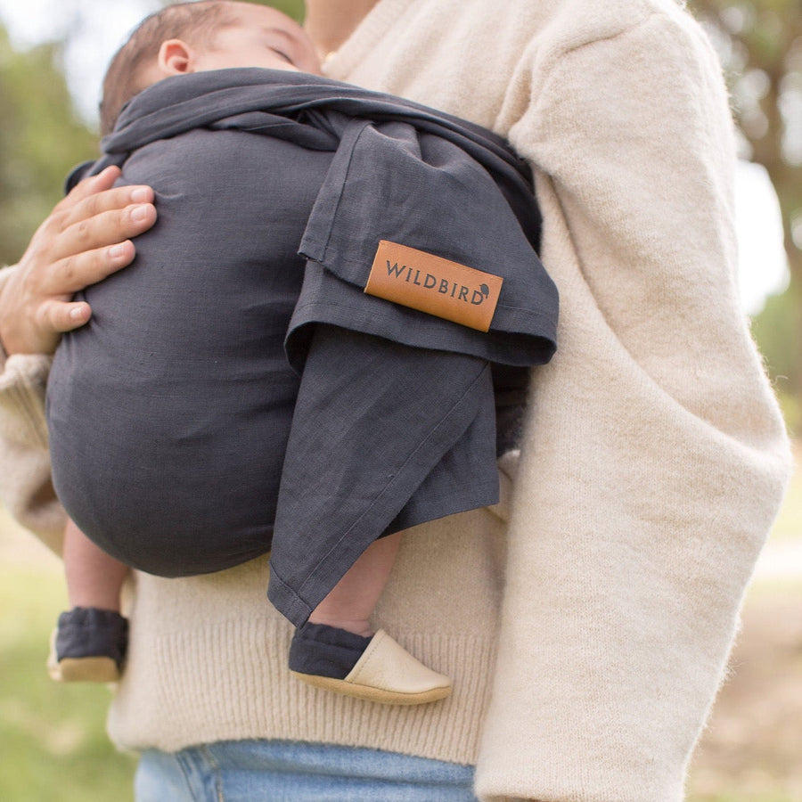 Baby in Wildbird Midnight carrier wearing matching baby shoes