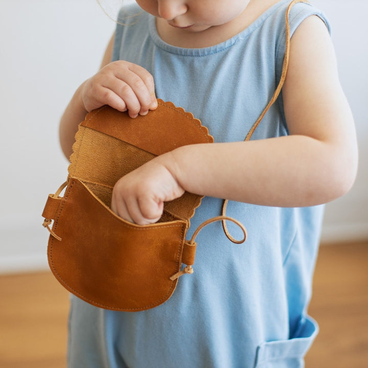 Toddler purse on toddler girl. Toddler hand in deep orange leather  purse