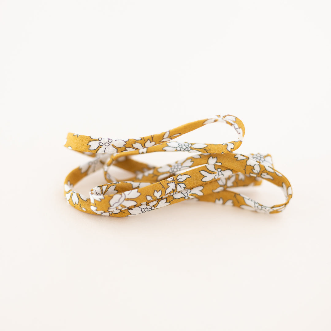 Floral-patterned yellow lanyard on a white background
