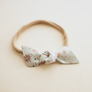 floral leather knotted bow baby headband. Soft nylon band.